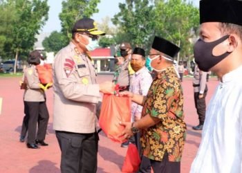 Kapoldasu Irjen Pol Drs Martuani Sormin MSi menyerahkan bantuan kepada warga yang terdampak Covid-19 di lapangan KS Tubun Mapolda Sumut, Selasa (21/4/2020).