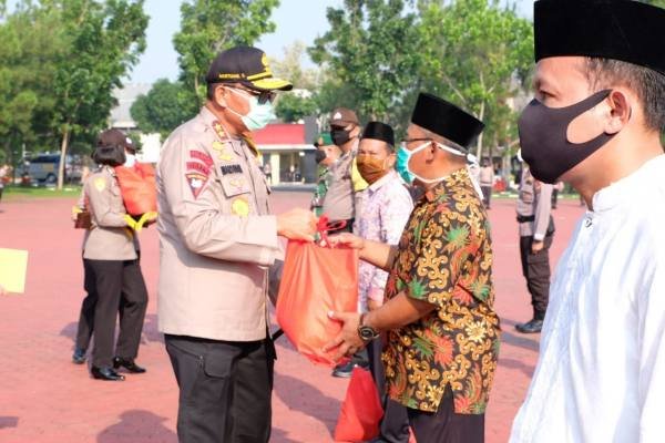 Kapoldasu Irjen Pol Drs Martuani Sormin MSi menyerahkan bantuan kepada warga yang terdampak Covid-19 di lapangan KS Tubun Mapolda Sumut, Selasa (21/4/2020).