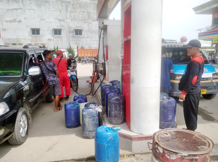 Petugas SPBU Galang Agus dan Erwin sempat terhenti sejenak ketika diabadikan wartawan. (foto: nasution)