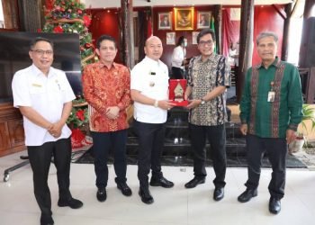 Bupati Taput Nikson Nababan tampak sedang bertukar cindera mata dengan komisioner Ombudsman RI di rumah dinas Bupati Taput, Rabu (30/11/2022).