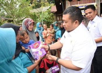 Bupati Tapsel Dolly Pasaribu saat menyerahkan bantuan makanan bergizi pada Masyarakat. (IST)