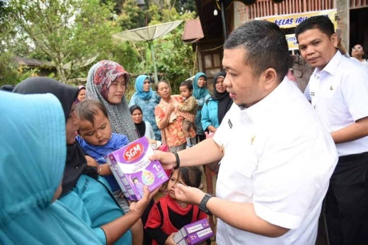 Bupati Tapsel Dolly Pasaribu saat menyerahkan bantuan makanan bergizi pada Masyarakat. (IST)