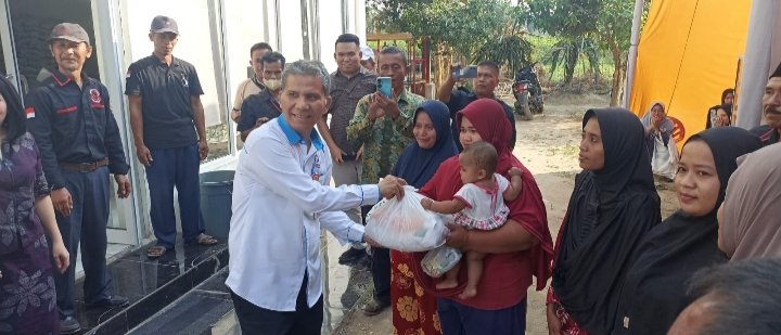 Kepala Ombudsman RI Perwakilan Sumut Abyadi  Siregar saat membagikan Sembako kepada warga pada penutupan pasar murah yang digelar KADIN Deli Serdang di Sei Rampah,Jumat (14/04/2023). (IST)