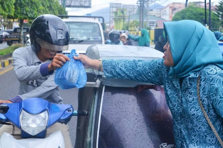 Ketua TP.PKK Linda Arwin Siregar saat membagikan takjil kepada para parbetor. (IST)