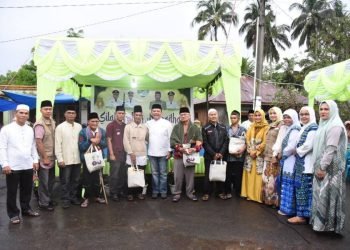 Pj.Sekda Taosel Parlindungan Harahap fhoto bersama dengan Masyarakat penerina bantuan. (IST)