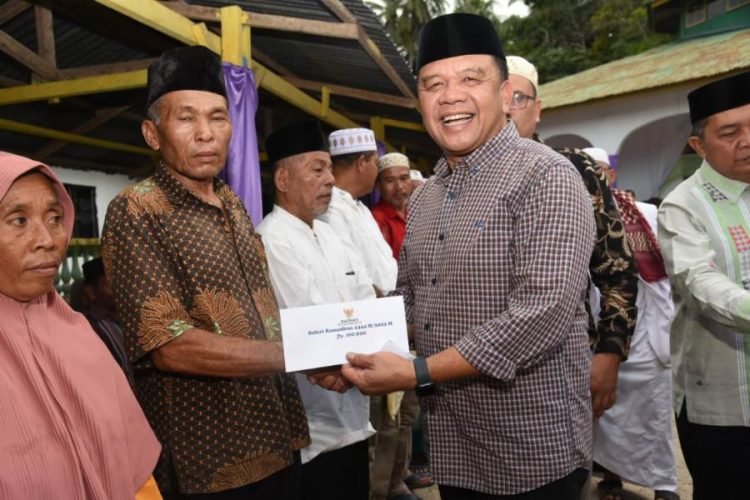 Pj. Sekda Tapsel Parlindungan Harahap  saat menterahkan bantuan pada  masyarakat Batang Angkola Kabupaten Tapsel. (IST)