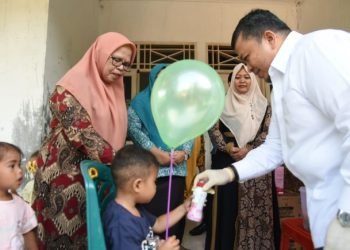 Bupati Tapsel Dolly Pasaribu memberi makanan tambahan pada para balita yang di Sub Pin Polio. (IST)