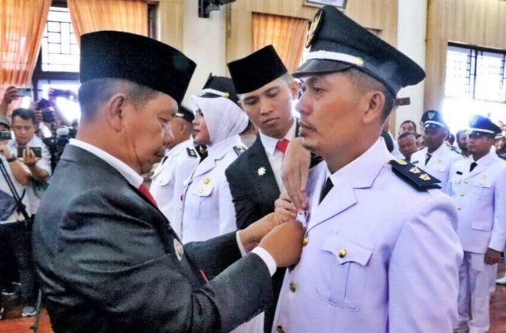 Bupati Simalungun Radiapoh Hasiholan Sinaga menyematkan tanda jabatan kepada Pangulu Nagori Buttu Turunan Kecamatan Hatonduan Roberto Nainggolan. (IST)