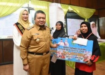 Bupati Tapsel Dolly Pasaribu dan Risakina Pasaribu saat memberikan uang pembinaan pada peserta PAUD yang berprestasi. (IST)