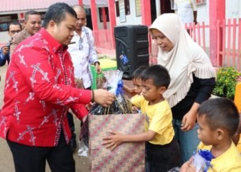 Bupati Tapsel Dolly Pasaribu saat memberikan bantuan pada keperluan sekolàh pada anak kembar tiga. (IST)