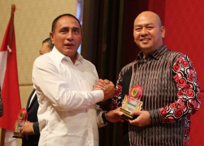 Tampak Bupati Taput Dr.Drs.Nikson Nababan, MSi sedang tersenyum bersama Gubsu Edy Rahmayadi seusai menerima piagam penghargaan Opini WTP 9 kali berturut-turut. (IST)