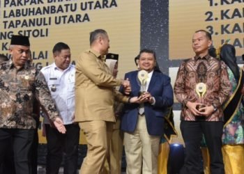 Bupati Tapsel Dolly Pasaribu saat menerima  Penghargaan Predikat Informatif dari Komisi Informasi Sumut. (IST)