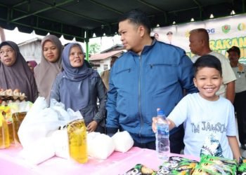 Bupati Tapsel, Dolly Pasaribu bersama anak Hasan Thariq saat meninjau kegiatan Gerakan Pangan Murah di Desa Huta tonga.  (IST)