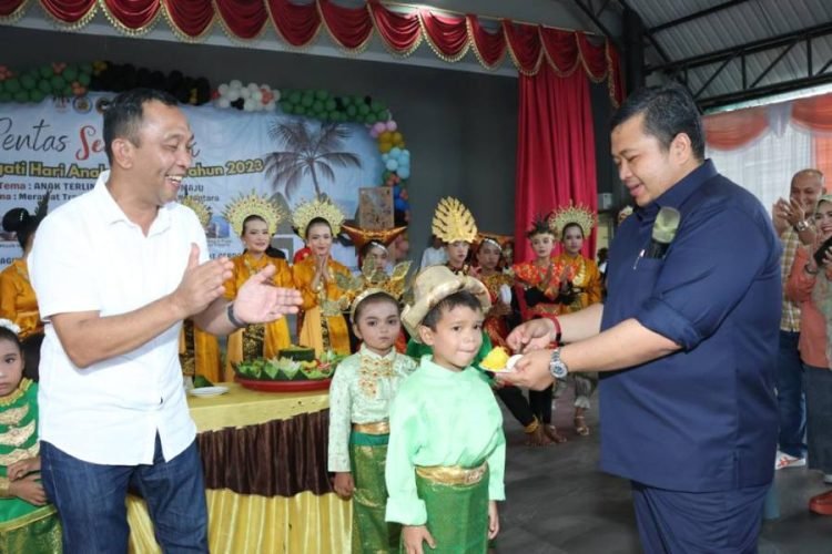 Bupati Tapsel Dolly Pasaribu memberikan Nasi Tumpeng pada para anak pada peringatan HAN. (IST)