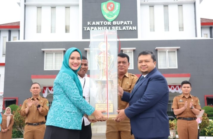 Bupati Tapsel Dolly Pasaribu dan nyoya memperlihatkan piala setelah meraih juara umum di tingkat provinsi Sumut. (IST)