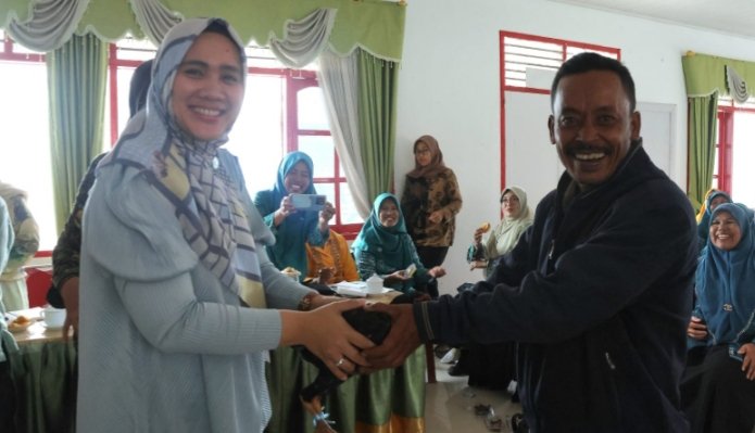 Ketua TP.PKK Rosalina Dolly Pasaribu menyerahkan seekor ayam pada Masyarakat Pargarutan. (IST)