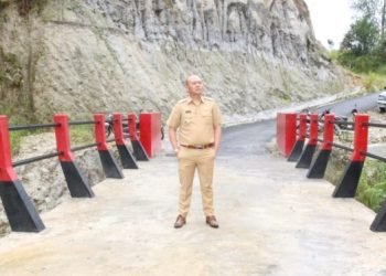 Bupati Tapanuli Utara Dr.DrsNikson Nababan, MSi sedang berfoto di jembatan Soekarno Desa Silando Muara, Selasa (24/10/2023). (IST)
