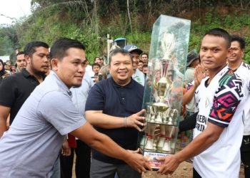 Bupati Tapsel Dolly Pasaribu menyerahkan piala bergilir pada juara turnamen Bola Voli Pal XI Cup di lapangan Bola Voli Desa Palsabolas, Kecamatan Angkola Timur, Jumat (20/10). (IST)