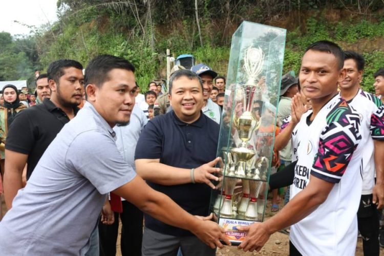 Bupati Tapsel Dolly Pasaribu menyerahkan piala bergilir pada juara turnamen Bola Voli Pal XI Cup di lapangan Bola Voli Desa Palsabolas, Kecamatan Angkola Timur, Jumat (20/10). (IST)