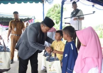 Bupati Tapsel Dolly Pasaribu saat memberikan bantuan pada anak yatim. (IST)