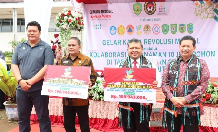 Bupati Tapsel saat menerima bantuan dari Mensos pada Gelar Karya Revolusi Mental melalui Kolaborasi Penanaman 10 Juta Pohon di Tapanuli Bagian Selatan (Tabagsel), yang digelar di Ponpes Muhammadiyah Ahmad Dahlan, Desa Kampung Setia, Kelurahan Baringin, Kecamatan Sipirok (23/11). (IST)