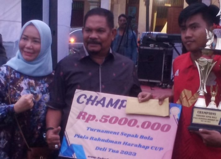Drs H Rahudman Harahap MM menyerahkan hadiah untuk tim yang meraih juara 1 turnamen Sepak Bola Rahudman Cup Delitua 2023. (SAMURA)