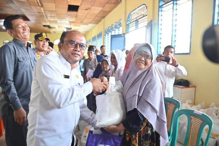Pj.Wali Kota Padangsidimpuan Letnan Dalimunthe saat menyalurkan bantuan pangan cadangan beras pemerintah pada salah satu penerima bantuan. (IST)