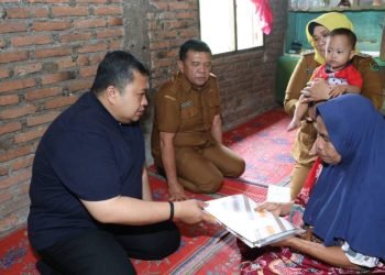 Bupati Tapsel Dolly Pasaribu  saat memberikan santunan kepada anak berkebutuhan khusus Arham Mumtaz di Desa Sorik, Kecamatan Batang Angkola (21/11). (IST)