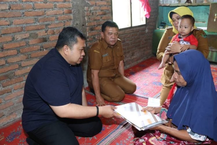 Bupati Tapsel Dolly Pasaribu saat memberikan santunan kepada anak berkebutuhan khusus Arham Mumtaz di Desa Sorik, Kecamatan Batang Angkola (21/11). (IST)