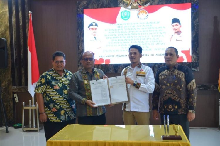 Pj.Wali Kota Padangsidimpuan Letnan Dalimunthe dan Ketua Bawaslu memperlihatkan NPHD yang ditandatangani bersama. (IST)
