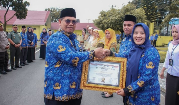 Plh. Sekdako Padangsidimpuan, H. Rahuddin Harahap saat menyerahkan piagam penghargaan pada salah seorang ASN. (IST)