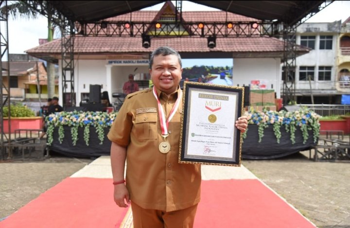 Bupati Tapsel Dolly Pasaribu memperlihatkan penghargaaan rekor dunia MURI melalui minum kopi dengan kulit manis sebanyak 4.000 cup. (IST)