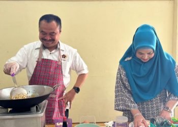 Ketua PWI Sumut Farianda Putra Sinik,SE  didampingi istri Fadia Achri Yulan tampak ikut lomba memasak nasi goreng. (IST)