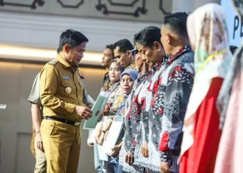 Penjabat (Pj) Gubernur Sumatera Utara (Sumut) Hassanudin menyerahkan sertifikat tanah secara simbolis pada masyarakat di Aula Raja Inal Siregar, Kantor Gubernur Sumut, Jalan Pangeran Diponegoro Nomor 30, Medan, Senin (4/12).  (DISKOMINFO SUMUT)