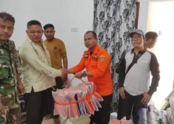 Kalaksa BPBD Tapsel Umar Halomoan Daulay  saat menyerahkan bantuan masyarakat yang terdampak bencana banjir berupa sembako, peralatan keluarga, selimut, karpet, biskuit dan tambahan gizi. (IST)