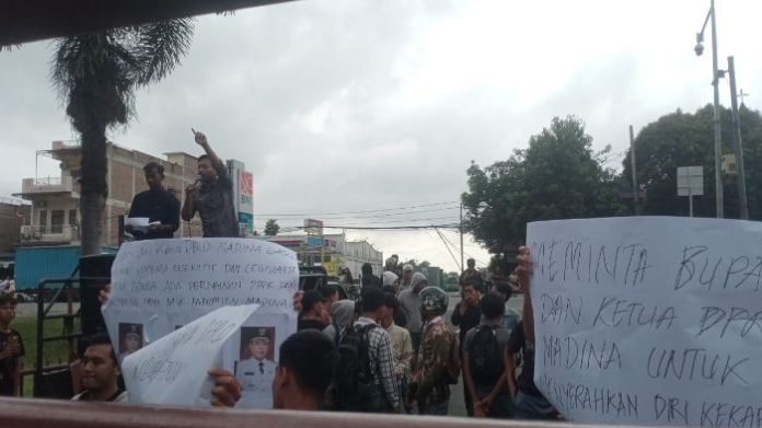 Puluhan massa yang datangi Polda Sumut untuk mendesak Bupati Madina ditangkap.