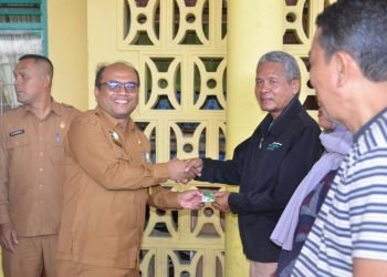 Pj. Wali Kota Padangsidimpuan, H. Letnan Dalimunthe saat menyerahkan Kartu BPJS Ketenagakerjaan pada Masyarakat. (IST)