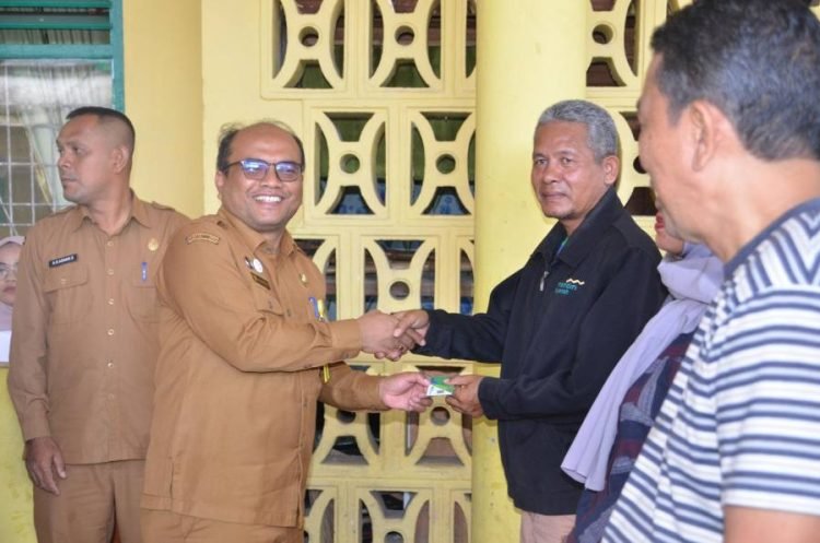 Pj. Wali Kota Padangsidimpuan, H. Letnan Dalimunthe saat menyerahkan Kartu BPJS Ketenagakerjaan pada Masyarakat. (IST)