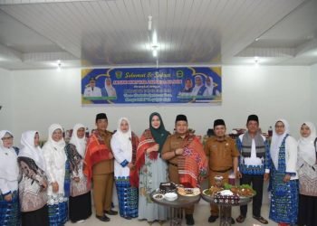 TP.PKK Tapsel Rosalina dan Bupati Tapsel Dolly saat dipakaikan ulos oleh Ketua BKMT  Rosmayanti Ritonga sekaligus disuapi indahan pangupa. (IST)