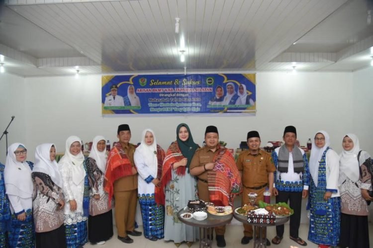 TP.PKK Tapsel Rosalina dan Bupati Tapsel Dolly saat dipakaikan ulos oleh Ketua BKMT  Rosmayanti Ritonga sekaligus disuapi indahan pangupa. (IST)