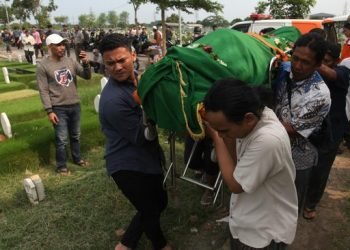 Warga menggotong jenazah Joko Budiono (51) untuk dimakamkan di Tempat Pemakaman Umum (TPU) Keputih, Surabaya, Jawa Timur, Jumat (16/2/2024). 