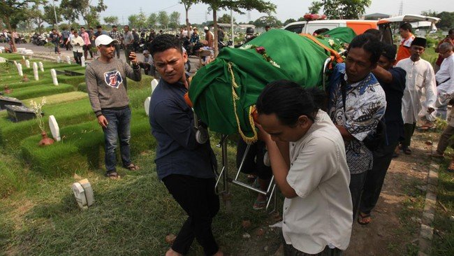 Warga menggotong jenazah Joko Budiono (51) untuk dimakamkan di Tempat Pemakaman Umum (TPU) Keputih, Surabaya, Jawa Timur, Jumat (16/2/2024).