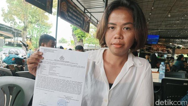 Rani Veronica Napitupulu (29) menunjukkan bukti pelaporan terhadap adik iparnya R.