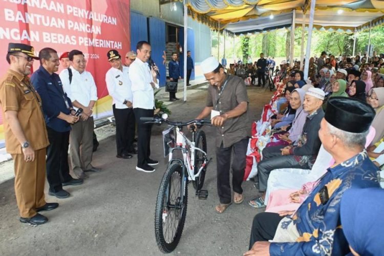 Penjabat (Pj) Gubernur Sumatera Utara (Sumut) Hassanudin  mendampingi Presiden RI Joko Widodo (Jokowi) menyalurkan bantuan pangan cadangan beras pemerintah di GDT Hutalombang, Padanglawas, Jumat (15/3).  (DISKOMINFO SUMUT)
