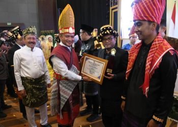 Pj.Wali Kota Padangsidimpuan Letnan Dalimunte saat menerima penghargaan dari Gubsu Hassanudin sebagai juara ke III Kota Pembangunan Daerah. (IST)