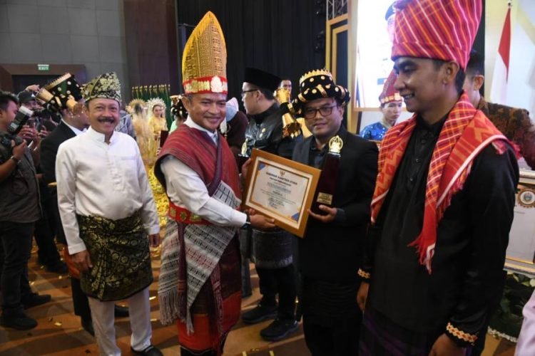 Pj.Wali Kota Padangsidimpuan Letnan Dalimunte saat menerima penghargaan dari Gubsu Hassanudin sebagai juara ke III Kota Pembangunan Daerah. (IST)