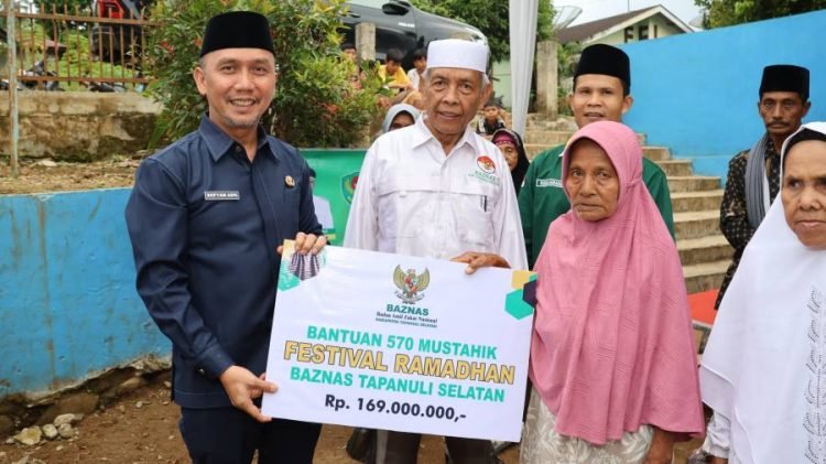 Sekda Tapsel Sofyan Adil menyerahkan santunan Baznas kepada 95 mustahik dari tiga kecamatan yakni Kecamatan Marancar, Kecamatan Batang Toru dan Kecamatan Muara Batang Toru. (IST)