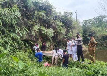 Pihak kepolisian bersama tim medis saat mengevakuasi jasad korban. 