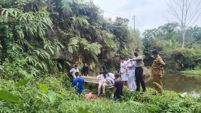 Pihak kepolisian bersama tim medis saat mengevakuasi jasad korban.