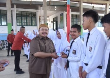 Bupati Tapsel Dolly Pasaribu saat menyerahkan e-KTP pada Siswadi SMAN 1 Angkola Barat Kabupaten Tapsel. (IST)